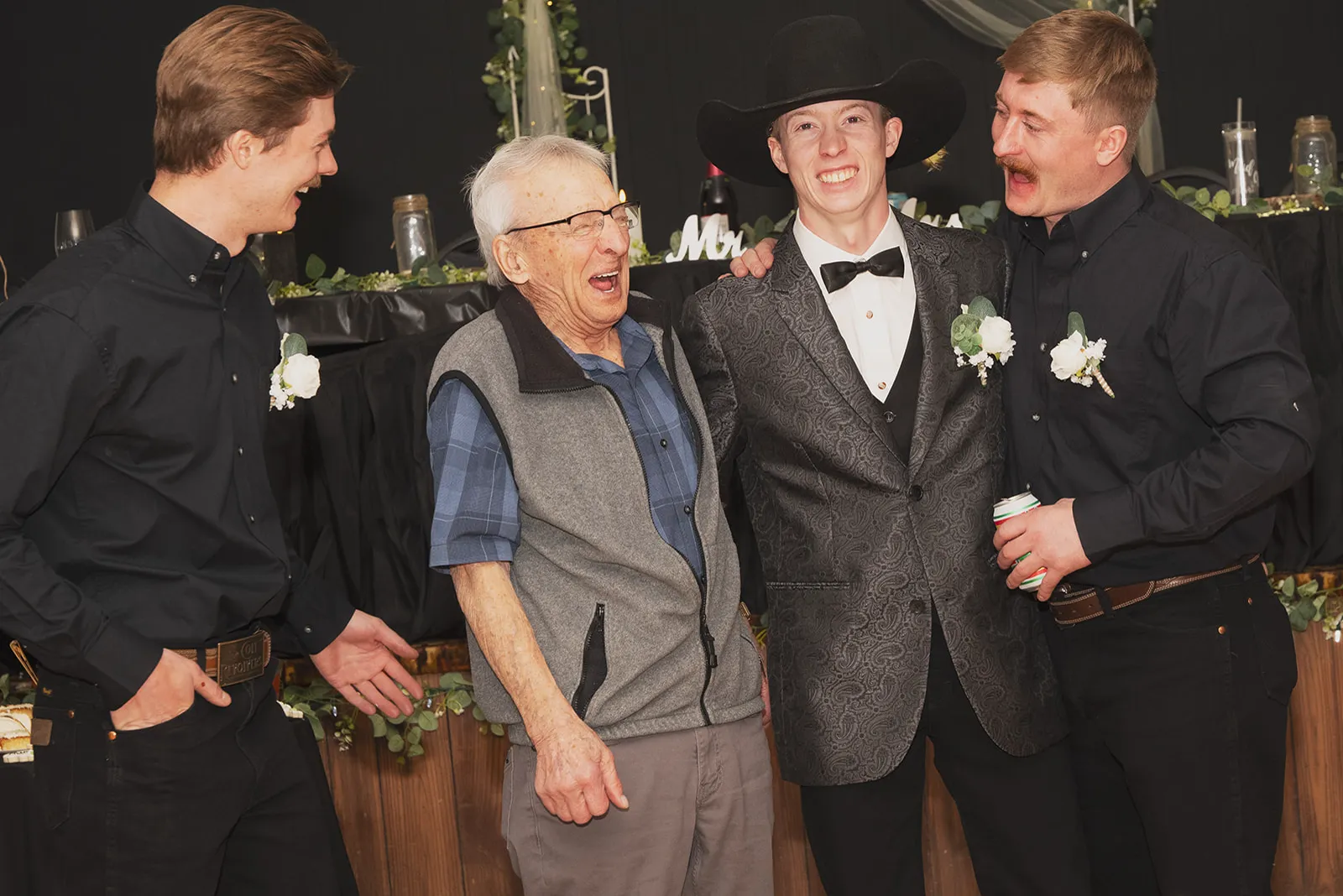 A grandpa laughing with the groom and groomsmen