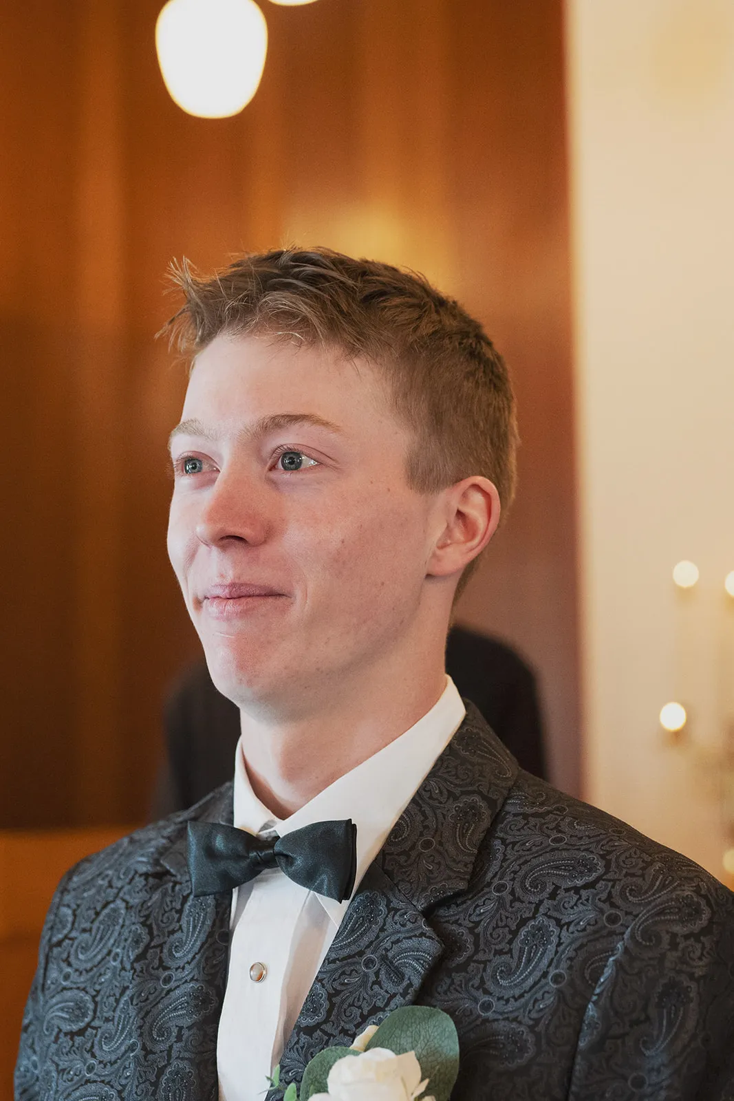 A groom tearing up as he sees his bride