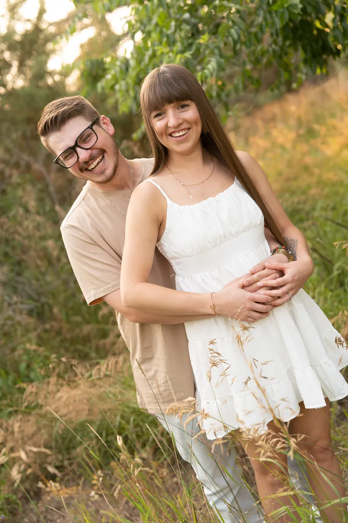 Couple laughing together in tall summer grass