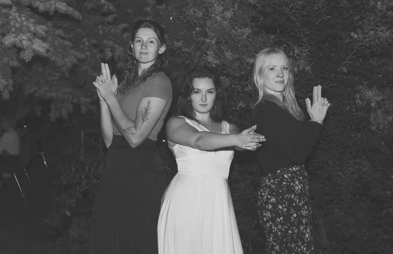 Bride and friends doing finger guns at night, black and white